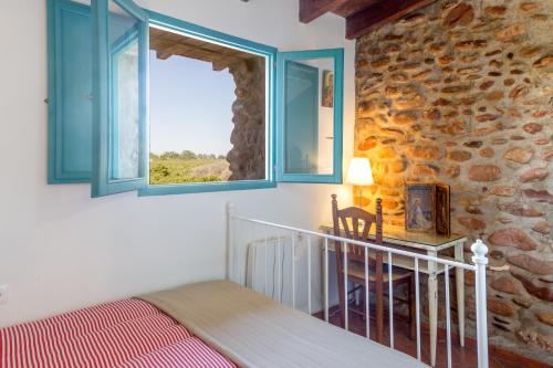 ein Schlafzimmer mit einem Bett und einer Steinwand in der Unterkunft Villa Rotonda in Alquerías del Niño Perdido