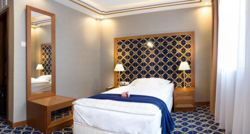 a hotel room with a bed and a mirror at Hotel Central in Nyíregyháza