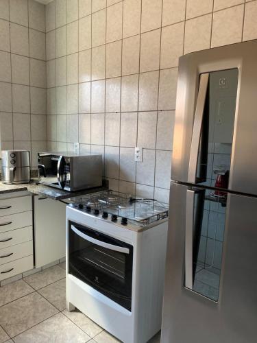 a kitchen with a stove and a refrigerator at Apto Central 9 hospedes in Água Boa