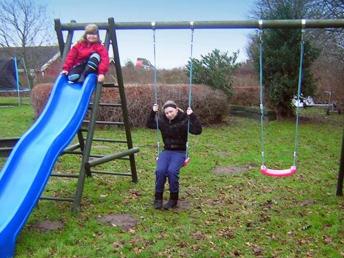 a man and a child on a swing at Modern Retreat with Spa - By Traum Ferienwohnungen in Nordborg