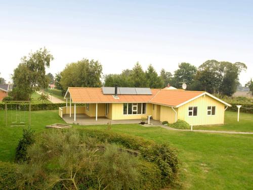 a yellow house with a red roof in a yard at Modern Retreat with Spa - By Traum Ferienwohnungen in Nordborg