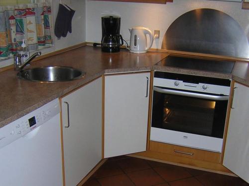 a kitchen counter with a sink and a stove at Modern Retreat with Spa - By Traum Ferienwohnungen in Nordborg