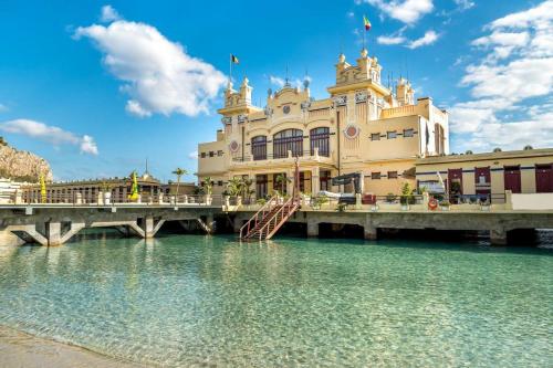 un edificio sobre un puente sobre un cuerpo de agua en Villa Oasi Bonita a Mondello, en Palermo