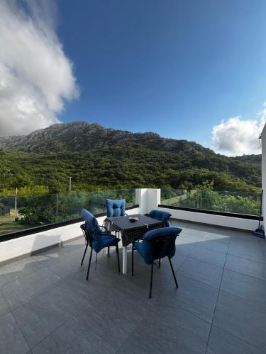 a table and chairs on a balcony with a mountain at House in Nature Milić in Čanj