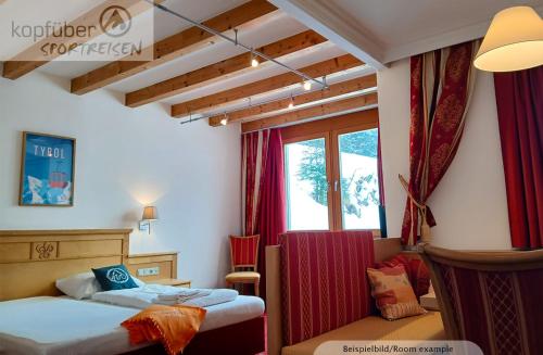 a bedroom with two beds and a window at Sporthotel Christophorus in Kappl
