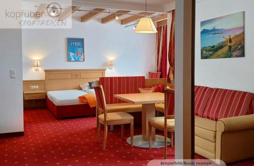 a hotel room with a bed and a table and chairs at Sporthotel Christophorus in Kappl