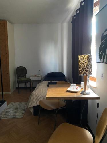 a room with a bed and a table with a lamp at Perk25A in Steenokkerzeel