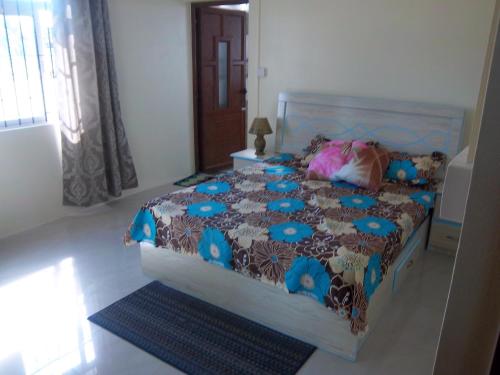 a bedroom with a bed with a blue comforter at Kaz Resident in Plaine Magnien