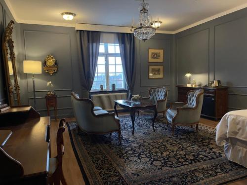 a room with a bed and a table and chairs at Eksjö Stadshotell in Eksjö