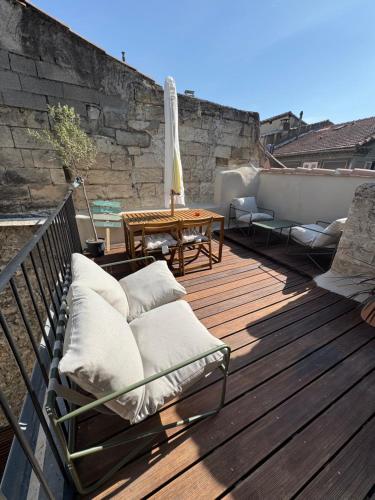 a patio with chairs and a table on a deck at Les Murmures du Palais - Terrasse privée avec vue in Avignon