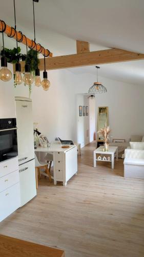 Maison cosy في Plobannalec-Lesconil: غرفة معيشة بها أثاث أبيض وطاولة