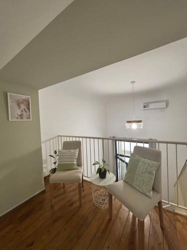 a room with two chairs and a table on a balcony at Sicily Loft Living in Catania