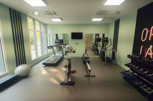 a gym with treadmills and exercise bikes in a room at Nemea Appart Hotel La Boetie Bordeaux Pessac in Pessac