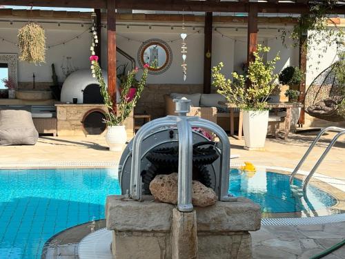 a swimming pool with a fountain next to a swimming pool at Little Stone House in Lymbia