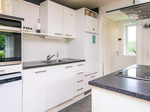 a kitchen with white cabinets and black counter tops at 5 person holiday home in Odder-By Traum in Odder