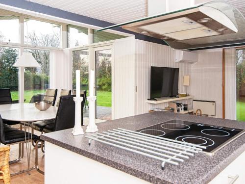 a kitchen with a stove top oven next to a table at 5 person holiday home in Odder-By Traum in Odder