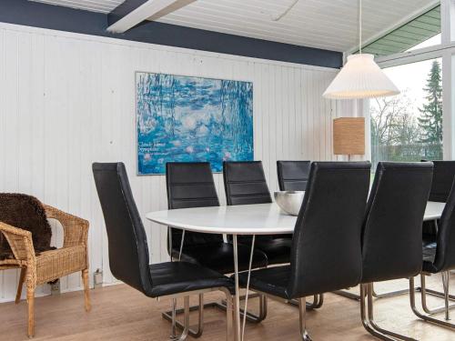 a dining room with a white table and black chairs at 5 person holiday home in Odder-By Traum in Odder