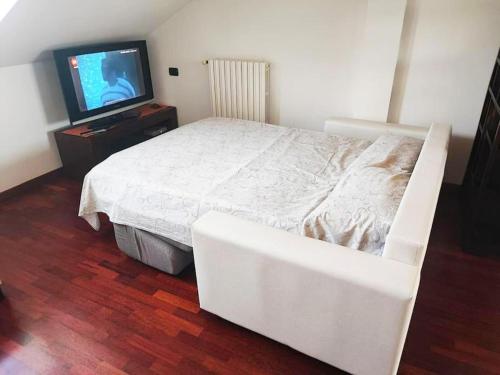 a bedroom with a white bed and a flat screen tv at Un posto tranquillo a Milano in Milan