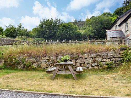 a picnic table in front of a stone wall at Lower Hameldown-Uk12424 in Widecombe in the Moor