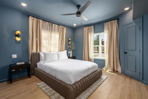 ein Schlafzimmer mit blauen Wänden, einem Bett und einem Fenster in der Unterkunft Luxe Spa Lounge, Gated 4 Parking, 2 linked Homes, Sleeps 20 in Houston