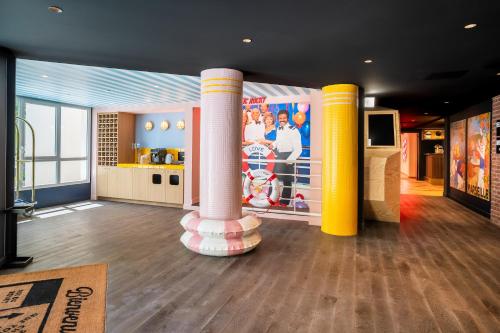 a room with columns and a tv in a building at RockyPop Marseille Hôtel in Marseille