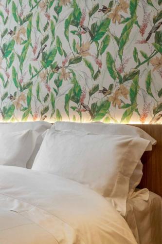 a bedroom with a floral wallpaper and a bed with a pillow at Pousada Flor de Anis in Alto Paraíso de Goiás