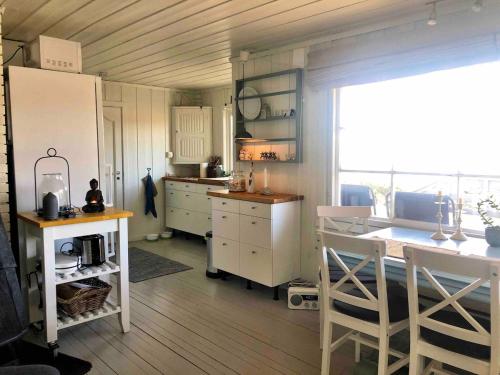 eine Küche mit weißen Schränken und einem großen Fenster in der Unterkunft Stavern Cottage with sea views near the beach in Larvik