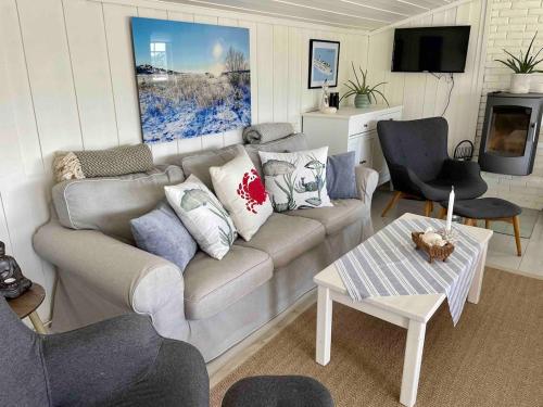 ein Wohnzimmer mit Sofa und Tisch in der Unterkunft Stavern Cottage with sea views near the beach in Larvik