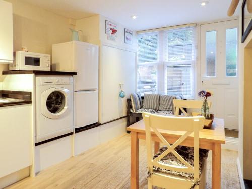 a kitchen with a table and a washer and dryer at The Snug, Lynmouth - Uk41696 in Lynmouth