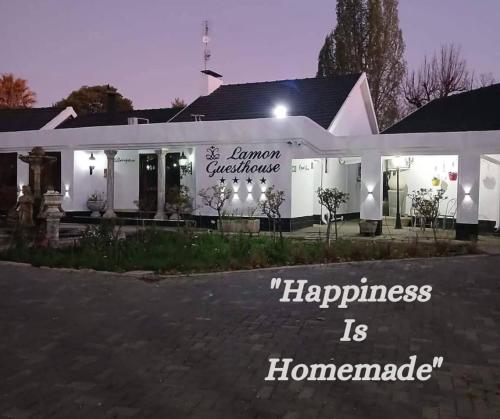 a building with a sign that reads happiness is homogeneous at Lamon Guesthouse in Kroonstad