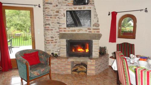 a living room with a brick fireplace and a chair at Trois logements indépendant au Grande Vigne in Saint-Étienne-sous-Bailleul