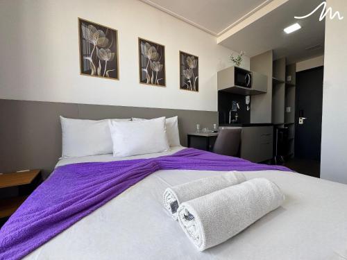 a bedroom with a large bed with a purple blanket at Move - Tambaú in Tambaú