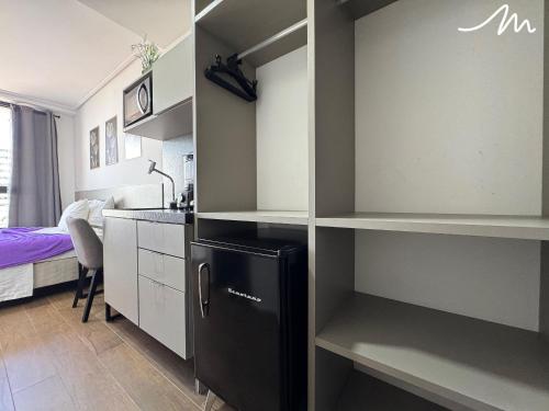 a kitchen with a black refrigerator in a room at Move - Tambaú in Tambaú