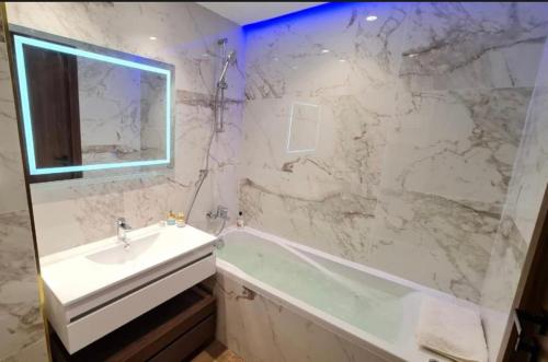 a white bathroom with a sink and a mirror at Luxury apartment in Sidi Daoud