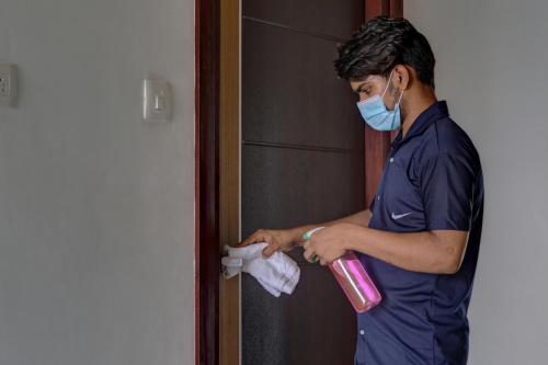 a man wearing a face mask and holding a pink container at Astra Hotels & Suites - Marathalli in Bengaluru