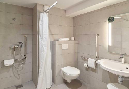 a bathroom with a shower and a toilet and a sink at B&B HOTEL Meaux Nanteuil-lès-Meaux in Nanteuil-lès-Meaux