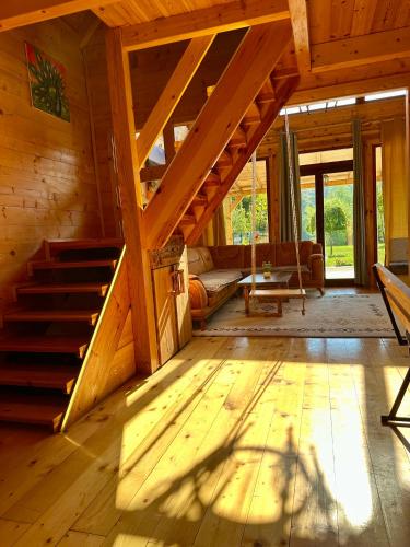 a room with wooden floors and stairs in a cabin at Dabar kuca za odmor in Banja Luka