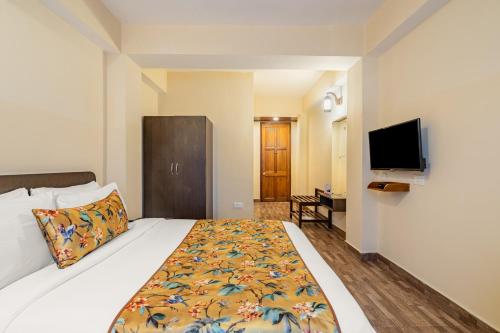 a hotel room with a bed and a flat screen tv at Summit Namnang Courtyard & Spa Near Mg Marg in Gangtok