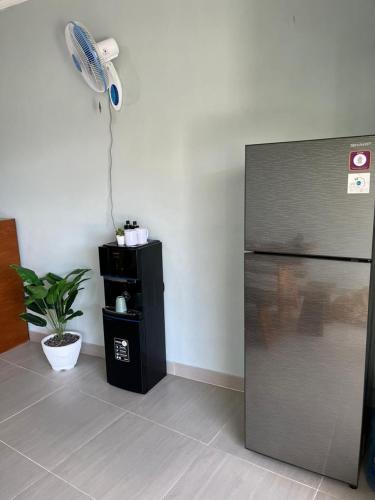 a kitchen with a refrigerator and a fan at Rumah Harmoni in Ungasan