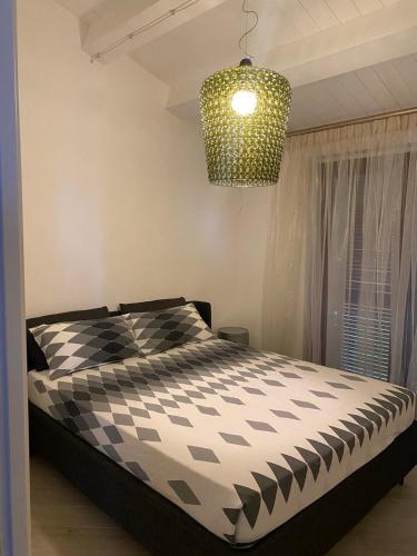 a bedroom with a black and white bed and a chandelier at Sole in Moresco