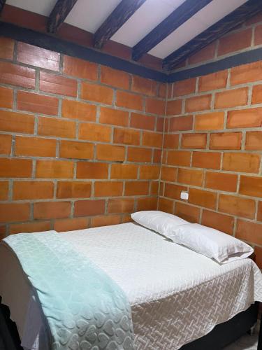 a brick wall with a bed in a room at Aloha Campestre in San Rafael