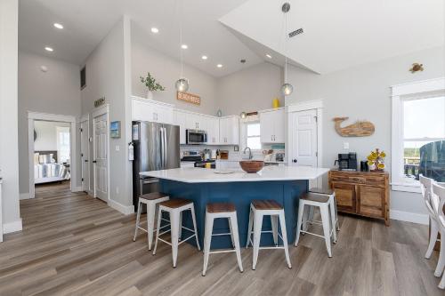 a kitchen with a blue island and stools at 8305 - The Sound of Sunshine in Avon