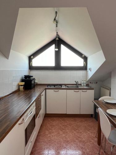 una cocina con fregadero y una ventana. en Mansarda Lucia, en Parma