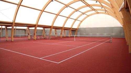 a tennis court with a domed ceiling and a tennis court at Domek wolnostojący na terenie Hotelu Trzy Podkowy in Biskupiec