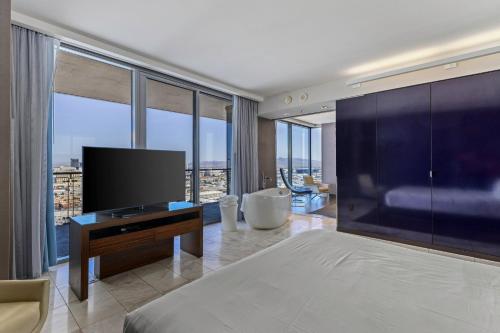 a bedroom with a large bed and a flat screen tv at Palms Place Condo Hotel & Casino in Las Vegas