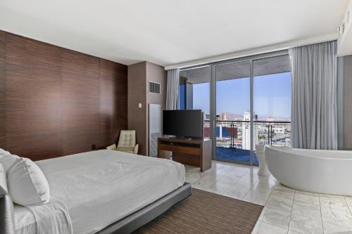 a bedroom with a tub and a television and a bed at Palms Place Condo Hotel & Casino in Las Vegas