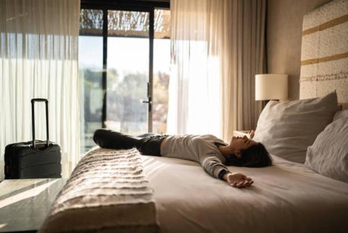a woman laying on a bed in a bedroom at Ineza Hotel Musanze - Snow Hotel in Ruhengeri