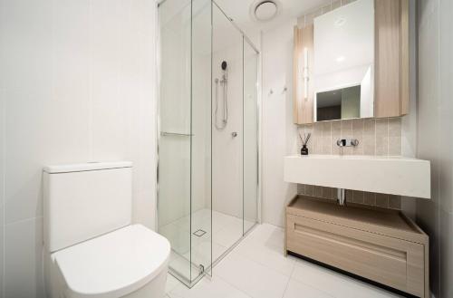 a bathroom with a toilet and a sink and a shower at Skyscraper Cinema - Dream a thousand city lights in Brisbane