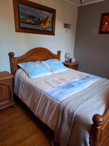 a bedroom with a large bed with a wooden headboard at Chez Fanfan in Cauville