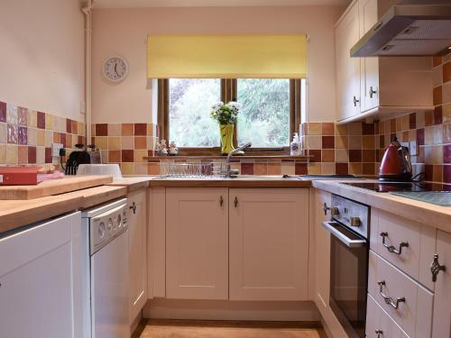 a kitchen with white cabinets and a sink and a window at The Cider Press in Welland